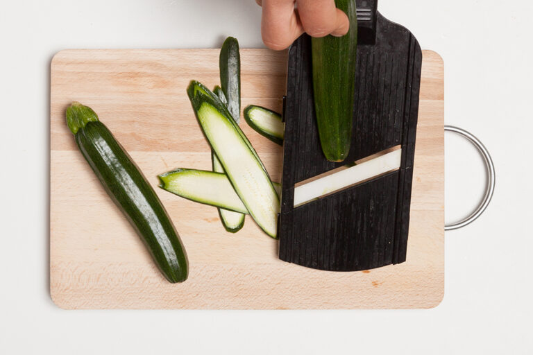 Utiliza una mandolina para lograr que las lonchas de tu calabacín queden uniformenete finas y así aportar un sabor más sutíl a tus calabacines.