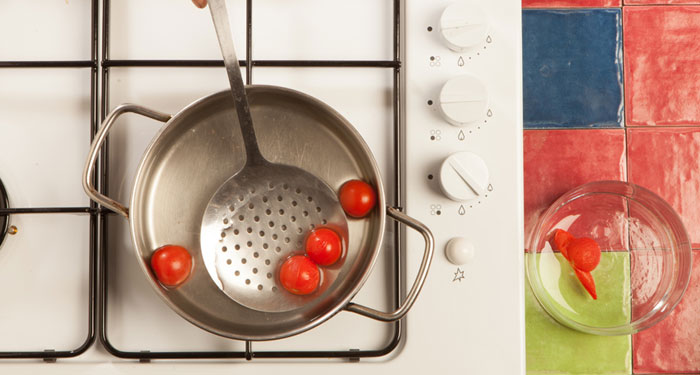 Quitar la piel los tomates cuando están crudos es una tarea un poco compleja, por eso, lo mejor es sumergirlos durante dos minutos en agua hirviendo.